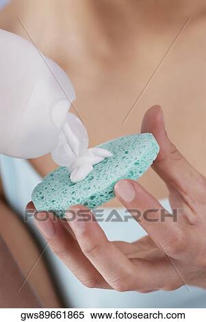 Mid section view of a young woman pouring moisturizer on a sponge View Large Photo Image Stock Photography - Mid section view of a young woman pouring moisturizer on a sponge. Fotosearch