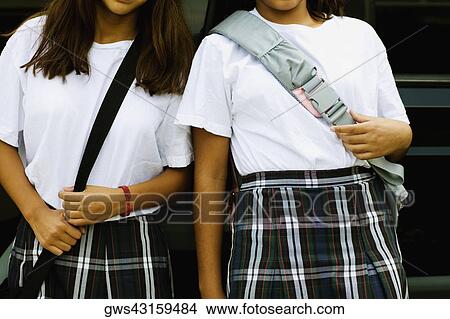 Mid section view of two schoolgirls View Large Photo Image Picture - Mid section view of two schoolgirls. Fotosearch
