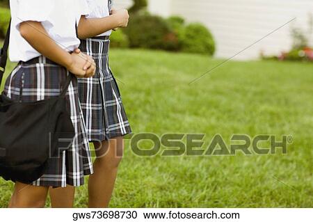Mid section view of two schoolgirls walking View Large Photo Image Stock Image - Mid section view of two schoolgirls walking. Fotosearch
