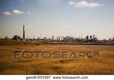 Stock Photo - Panoramic view of a field with a city in the background. Fotosearch