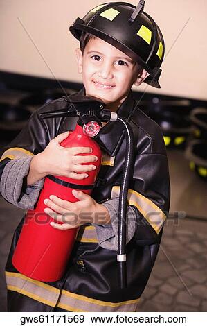 Portrait of a boy dressed as a firefighter and holding a fire extinguisher View Large Photo Image Stock Photo - Portrait of a boy dressed as a firefighter and holding a fire extinguisher. Fotosearch
