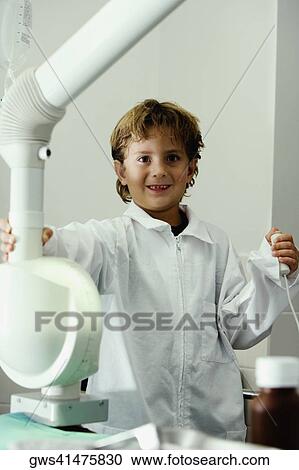 Portrait of a boy imitating a doctor and operating an X-Ray machine View Large Photo Image Stock Image - Portrait of a boy imitating a doctor and operating an X-Ray machine. Fotosearch