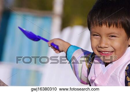 Portrait of a boy in traditional clothing holding a shovel View Large Photo Image Stock Image - Portrait of a boy in traditional clothing holding a shovel. Fotosearch