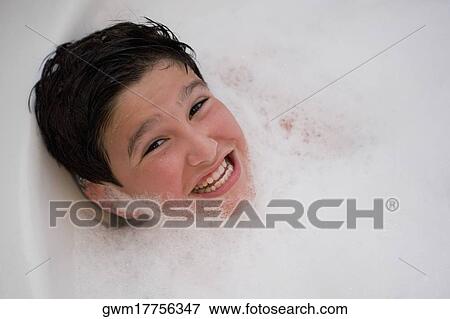 Stock Photo - Portrait of a boy smiling in a bubble bath. Fotosearch