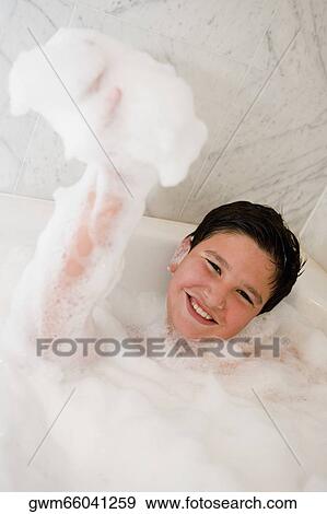 Stock Photo - Portrait of a boy smiling in a bubble bath. Fotosearch