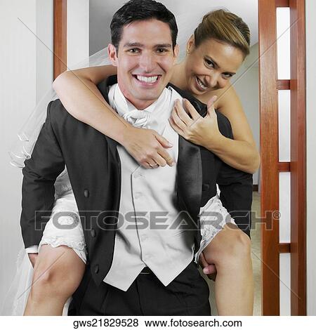 Portrait of a bride riding piggyback on her groom View Large Photo Image Stock Photo - Portrait of a bride riding piggyback on her groom. Fotosearch