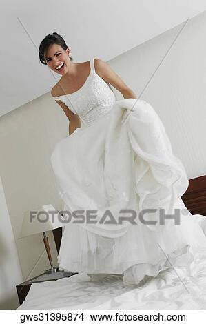 Picture - Portrait of a bride standing on the bed. Fotosearch