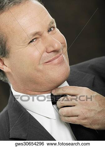 Portrait of a businessman adjusting his tie View Large Photo Image Stock Photograph - Portrait of a businessman adjusting his tie. Fotosearch