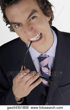 Portrait of a businessman biting his sunglasses View Large Photo Image Stock Photograph - Portrait of a businessman biting his sunglasses. Fotosearch