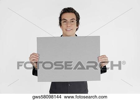Portrait of a businessman holding a blank placard View Large Photo Image Picture - Portrait of a businessman holding a blank placard. Fotosearch