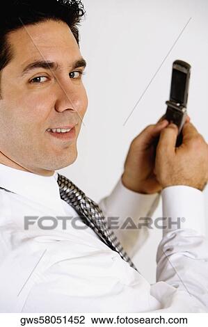 Portrait of a businessman holding a mobile phone and smiling View Large Photo Image Stock Image - Portrait of a businessman holding a mobile phone and smiling. Fotosearch