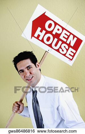 Stock Photograph - Portrait of a businessman holding a placard and smiling. Fotosearch