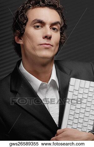 Portrait of a businessman holding a computer keyboard View Large Photo Image Stock Photography - Portrait of a businessman holding a computer keyboard. Fotosearch