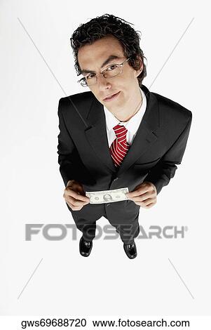 Portrait of a businessman holding an American dollar bill View Large Photo Image Stock Image - Portrait of a businessman holding an American dollar bill. Fotosearch