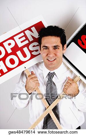 Picture - Portrait of a businessman holding two signboards. Fotosearch