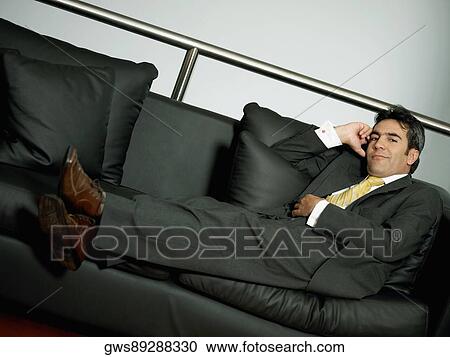 Portrait of a businessman reclining on a couch View Large Photo Image Stock Image - Portrait of a businessman reclining on a couch. Fotosearch
