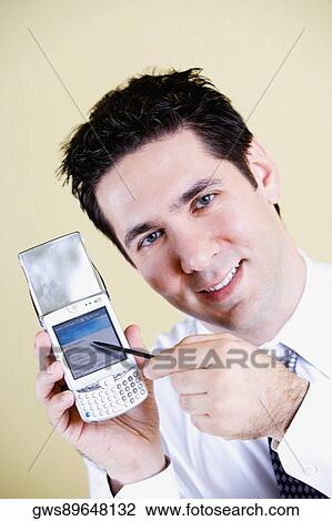 Portrait of a businessman showing a mobile phone View Large Photo Image Stock Image - Portrait of a businessman showing a mobile phone. Fotosearch