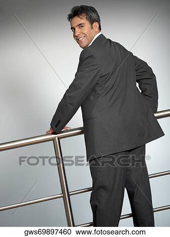 Portrait of a businessman standing near a railing View Large Photo Image Stock Image - Portrait of a businessman standing near a railing. Fotosearch