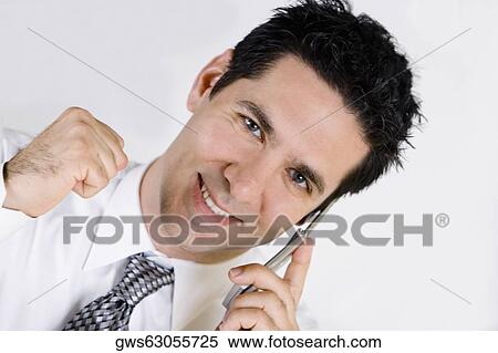 Stock Photography - Portrait of a businessman talking on a mobile phone and smiling. Fotosearch