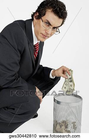 Portrait of a businessman throwing paper currency into a wastepaper basket View Large Photo Image Stock Image - Portrait of a businessman throwing paper currency into a wastepaper basket. Fotosearch