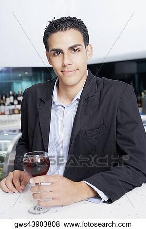 Portrait of a businessman with a glass of wine at a bar counter View Large Photo Image Stock Photo - Portrait of a businessman with a glass of wine at a bar counter. Fotosearch