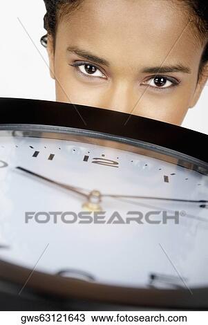 Portrait of a businesswoman behind a clock View Large Photo Image Stock Image - Portrait of a businesswoman behind a clock. Fotosearch