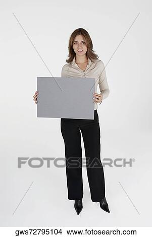 Picture - Portrait of a businesswoman holding a placard and smiling. Fotosearch