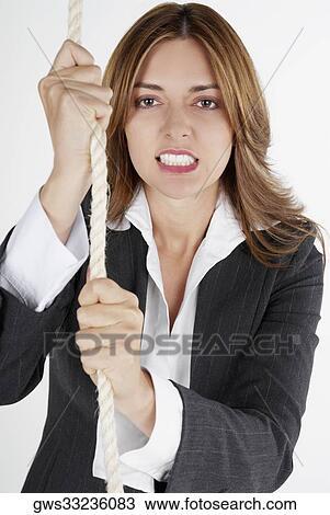 Portrait of a businesswoman holding a rope and clenching her teeth View Large Photo Image Stock Image - Portrait of a businesswoman holding a rope and clenching her teeth. Fotosearch