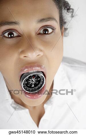 Portrait of a businesswoman holding a compass in her mouth View Large Photo Image Stock Image - Portrait of a businesswoman holding a compass in her mouth. Fotosearch