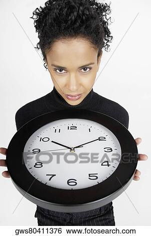 Portrait of a businesswoman holding a clock View Large Photo Image Stock Photograph - Portrait of a businesswoman holding a clock. Fotosearch