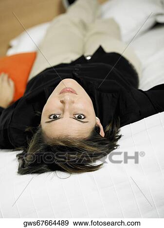 Stock Photo - Portrait of a businesswoman lying on the bed. Fotosearch