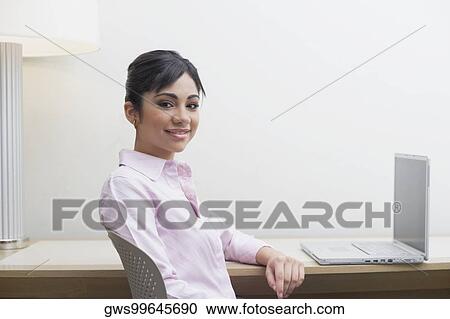 Portrait of a businesswoman sitting in front of a laptop View Large Photo Image Stock Image - Portrait of a businesswoman sitting in front of a laptop. Fotosearch
