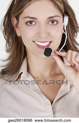Stock Photograph - Portrait of a female customer service representative talking on a headset and smiling. Fotosearch