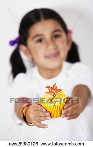 Stock Photograph - Portrait of a girl holding a cupcake. Fotosearch