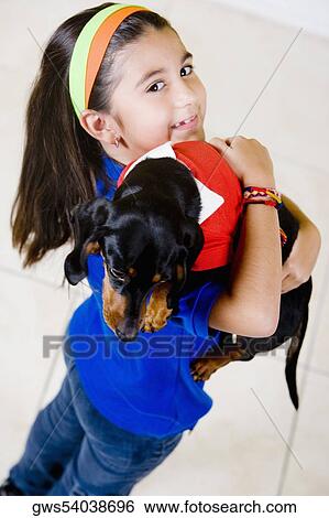 Portrait of a girl holding a puppy on her shoulder and smiling View Large Photo Image Stock Photograph - Portrait of a girl holding a puppy on her shoulder and smiling. Fotosearch