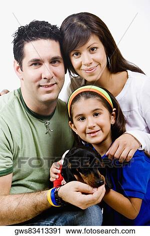 Portrait of a girl holding a puppy with her mother and father View Large Photo Image Stock Image - Portrait of a girl holding a puppy with her mother and father. Fotosearch