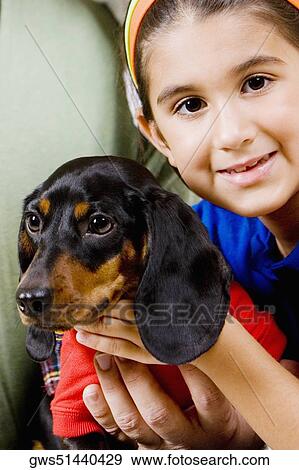 Portrait of a girl holding a puppy with her mother and father View Large Photo Image Stock Photo - Portrait of a girl holding a puppy with her mother and father. Fotosearch