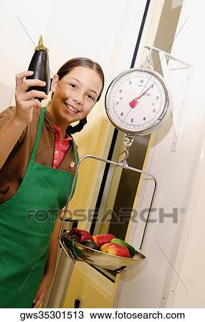 Portrait of a girl holding an eggplant and weighing vegetables View Large Photo Image Stock Image - Portrait of a girl holding an eggplant and weighing vegetables. Fotosearch