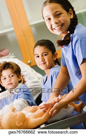 Portrait of a girl massaging a doll with her friends standing beside her View Large Photo Image Stock Image - Portrait of a girl massaging a doll with her friends standing beside her. Fotosearch
