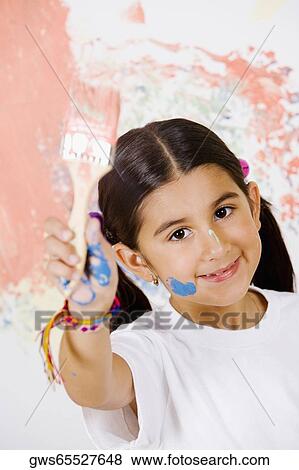 Portrait of a girl showing a paintbrush and smiling View Large Photo Image Stock Photo - Portrait of a girl showing a paintbrush and smiling. Fotosearch