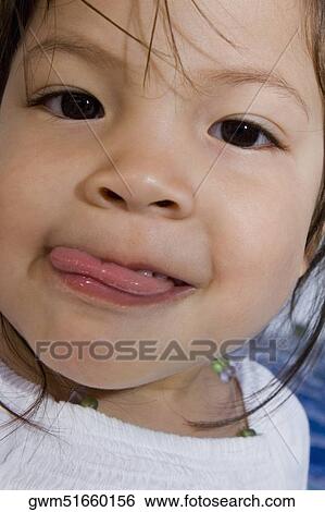 Portrait of a girl with sticking her tongue out View Large Photo Image Stock Photograph - Portrait of a girl with sticking her tongue out. Fotosearch