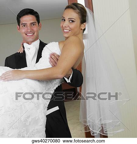 Portrait of a groom carrying his bride View Large Photo Image Stock Image - Portrait of a groom carrying his bride. Fotosearch