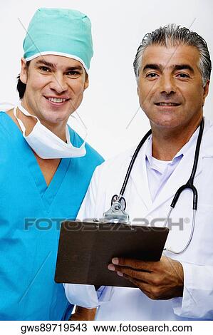 Portrait of a male doctor and a male surgeon standing together and smiling View Large Photo Image Stock Image - Portrait of a male doctor and a male surgeon standing together and smiling. Fotosearch