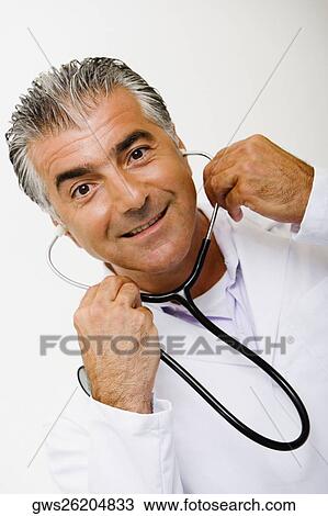 Portrait of a male doctor holding a stethoscope and smiling View Large Photo Image Stock Image - Portrait of a male doctor holding a stethoscope and smiling. Fotosearch