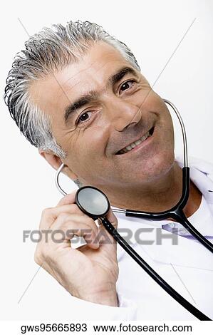 Portrait of a male doctor holding a stethoscope and smiling View Large Photo Image Stock Image - Portrait of a male doctor holding a stethoscope and smiling. Fotosearch