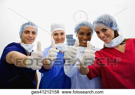 Portrait of a male surgeon and three female surgeons making Thumbs Up sign View Large Photo Image Stock Photo - Portrait of a male surgeon and three female surgeons making Thumbs Up sign. Fotosearch