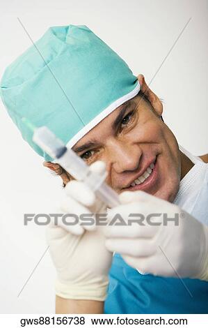 Portrait of a male surgeon holding a syringe View Large Photo Image Stock Photo - Portrait of a male surgeon holding a syringe. Fotosearch