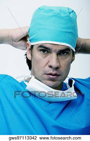 Portrait of a male surgeon tying his surgical cap View Large Photo Image Stock Image - Portrait of a male surgeon tying his surgical cap. Fotosearch