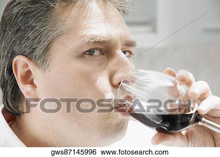 Portrait of a mature man drinking a glass of red wine View Large Photo Image Stock Photograph - Portrait of a mature man drinking a glass of red wine. Fotosearch