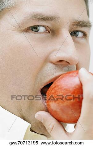 Portrait of a mature man eating an apple View Large Photo Image Stock Photography - Portrait of a mature man eating an apple. Fotosearch